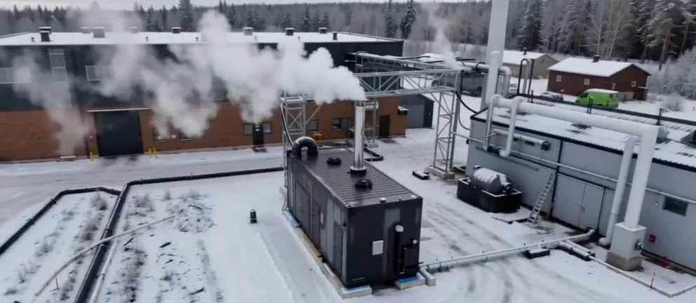 A BoilerGreen hybrid boiler container outside a factory in winter, with steam rising